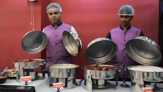Hotel CAPS catering team serving freshly prepared dishes from buffet counters