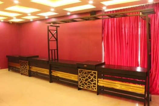 Hotel CAPS Events Hall stage with red backdrop and decorative seating