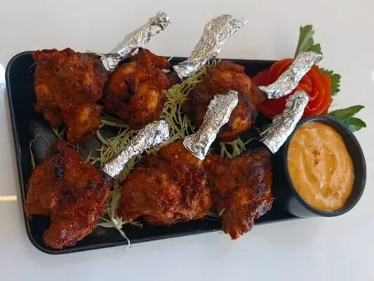 Grilled chicken pieces served with vegetables and dipping sauce